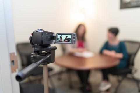 Image of two UNH students practicing interviewing in front of a camera